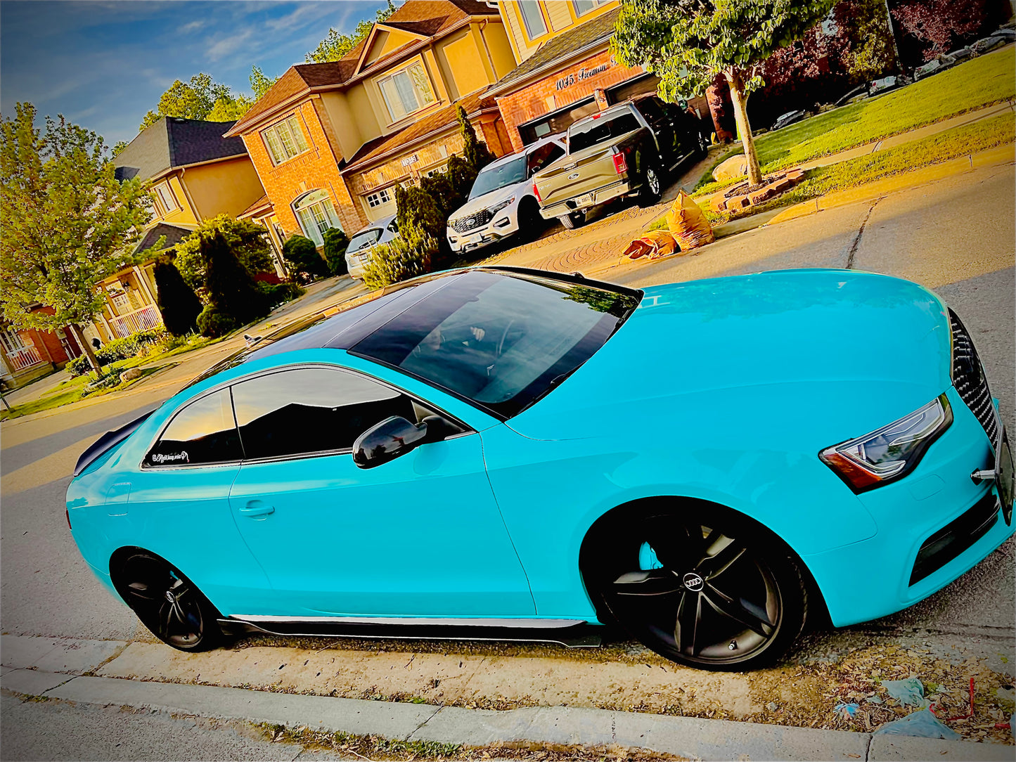 Audi coupe with custom gloss black side skirts installed, showcasing sporty stance and street-style modifications – OneCarWorld automotive upgrade.