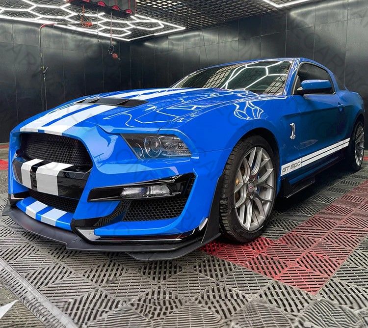 Blue Mustang with GT500 front bumper upgrade from OneCarWorld — front view with performance styling and hood vents