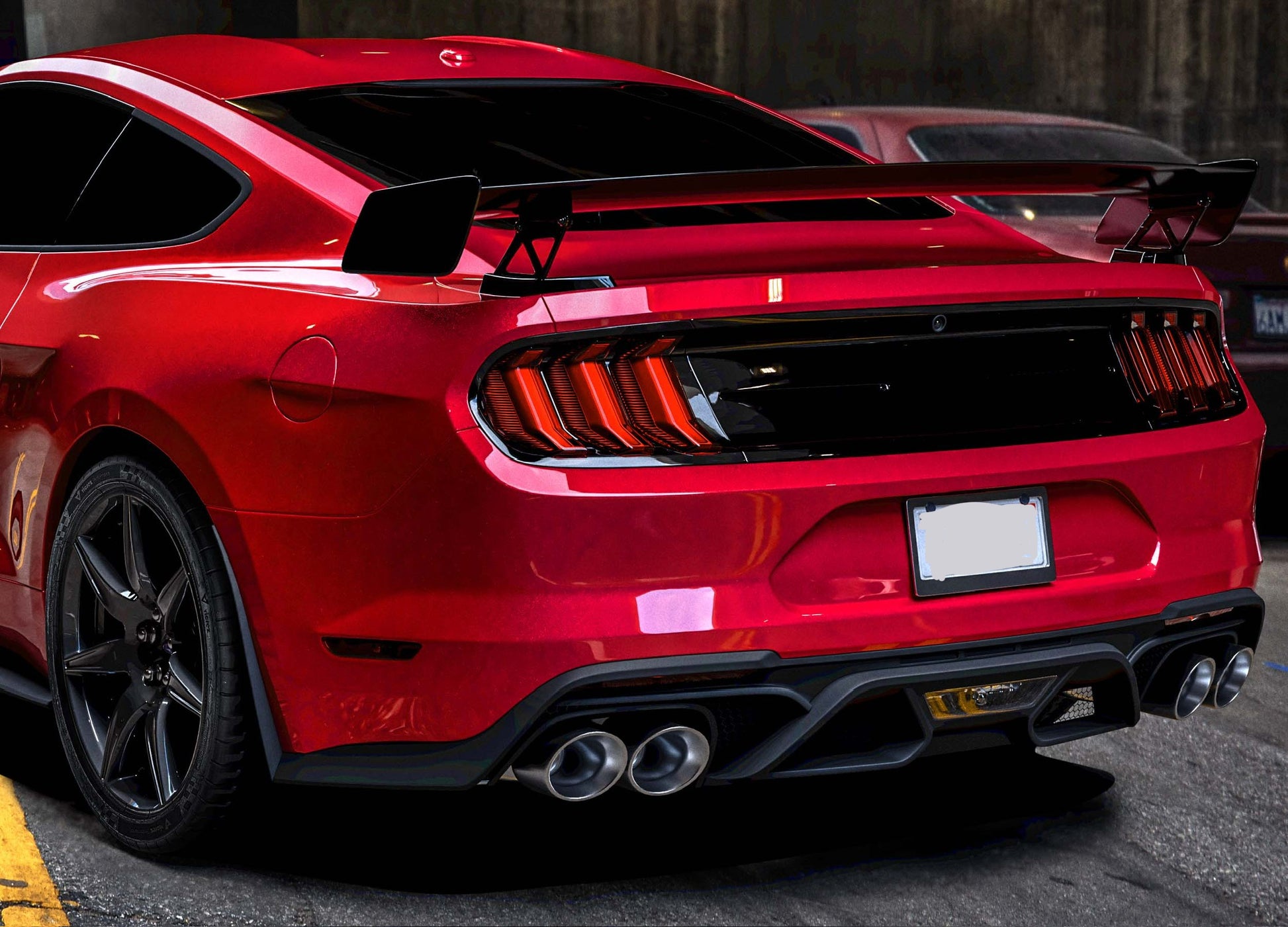 Matte black GT500-style rear diffuser installed on a 2018–2023 Ford Mustang, featuring quad exhaust cutouts and aggressive track-inspired rear design.